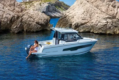 motorboot in kalm blauw water bij rotsen