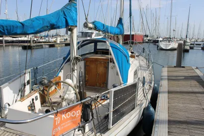 zeiljacht aan steiger met blauwe zeilhoes