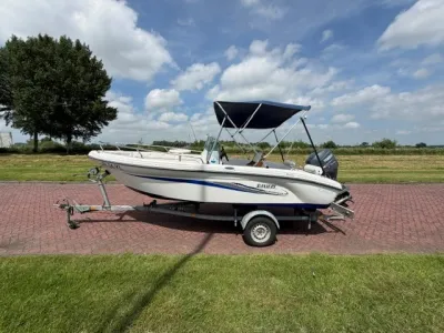 consoleboot op trailer naast gras en weg