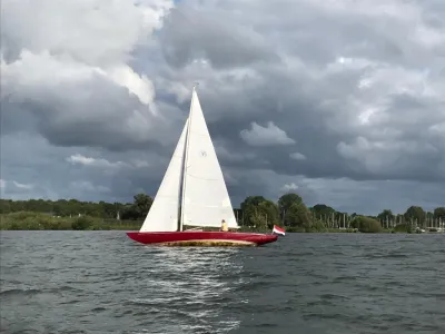 zeilboot op open water bij bewolkte hemel