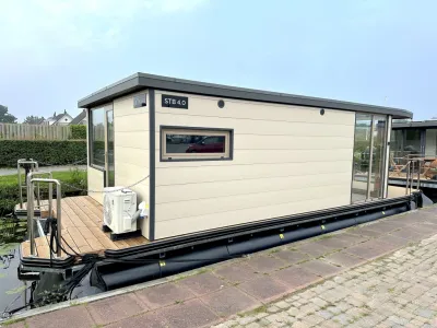 beige woonark aangemeerd langs kade