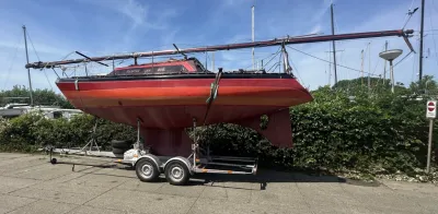 rood zeiljacht op trailer in jachthaven