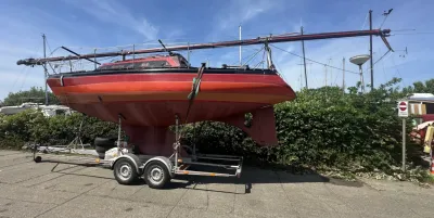rood zeiljacht op trailer bij werf