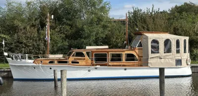 houten motorjacht aangemeerd bij kade