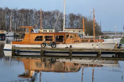 houten motorjacht afgemeerd in haven