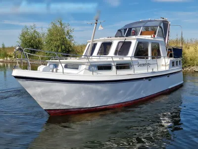 wit motorjacht in water bij oever