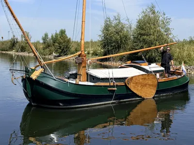 groene traditionele tjalk op het water