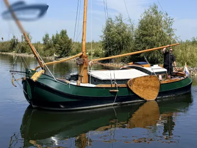 groene traditionele tjalk op het water