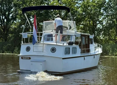 wit motorjacht met persoon bij het stuur