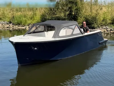 tendersloep met kap op rustig water