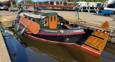 houten zeilboot afgemeerd naast kade