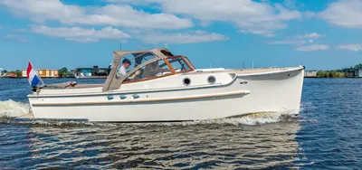 witte cabinsloep op water met blauwe lucht