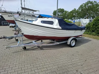 kleine visboot op trailer op parkeerplaats