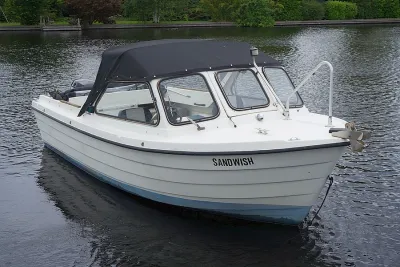 witte motorboot met zwarte kap op het water