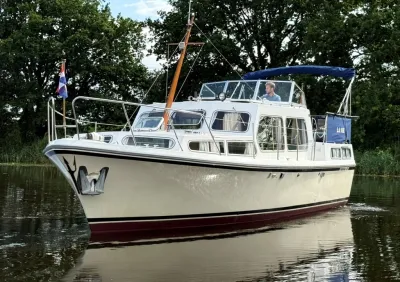 motorjacht op rivier met bomen op achtergrond