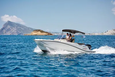 open consoleboot op zee met bimini en passagiers