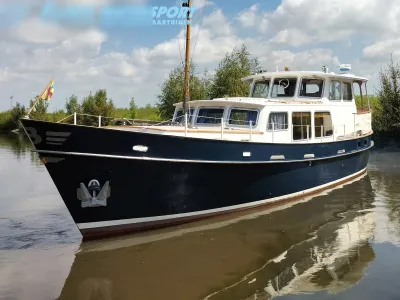 motorschip aangemeerd bij een oever