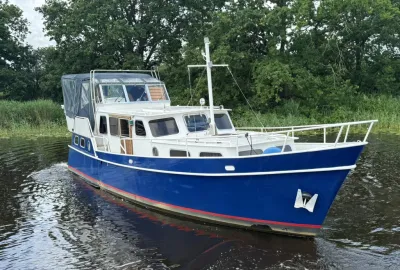 blauw kotterjacht op rivier met bomen