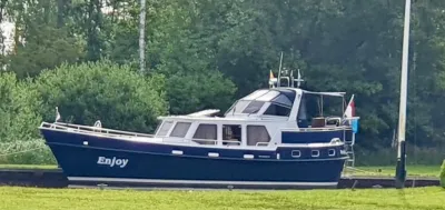 motorjacht afgemeerd langs de oever
