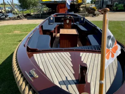 houten open sloep op gras