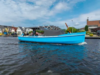 blauwe cabinsloep in kanaal