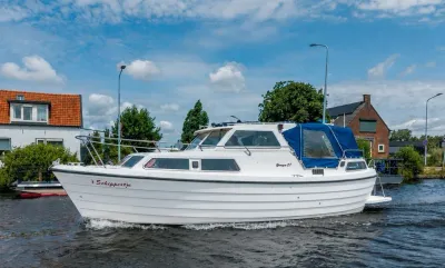 motorboot met hardtop op kanaal bij huizen