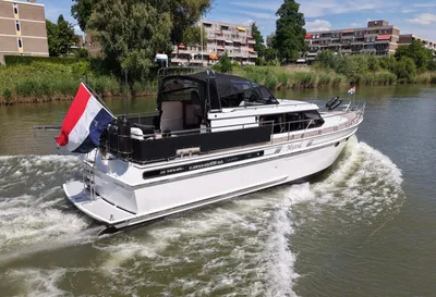 motorjacht op kanaal met bebouwing op oever