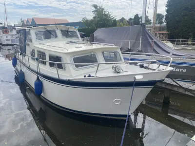 wit motorjacht aangemeerd in jachthaven