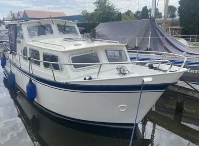 wit motorjacht aangemeerd in jachthaven