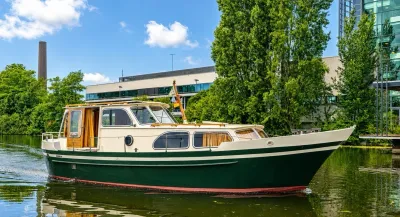 groen-wit motorjacht op binnenwater