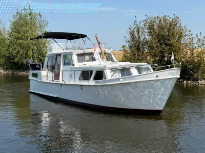 wit motorjacht aan het water bij oever