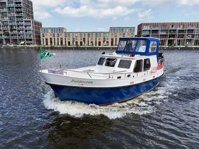 varend motorjacht bij woongebouw