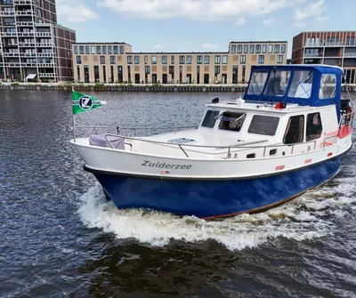 varend motorjacht bij woongebouw