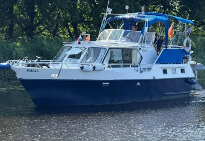 wit-blauw motorjacht op water met kuiptent