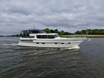 wit motorjacht op rivier bij bewolkte lucht