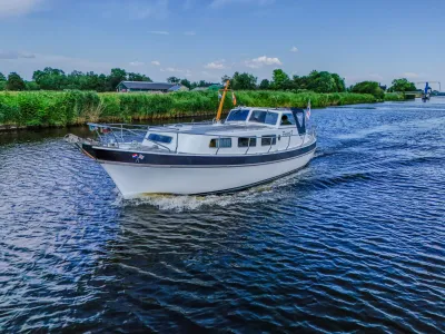 motorjacht op kanaal bij groene oever