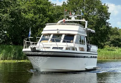 motorjacht varend op een rivier bij bomen