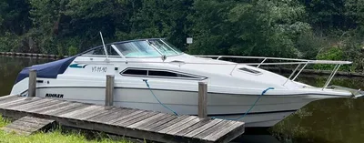 wit motorjacht aangemeerd naast houten steiger