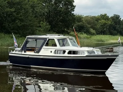 motorjacht op rustig water met bomen