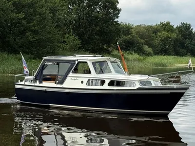 motorjacht op water met groene oever