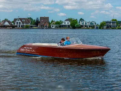 houten motorboot op water met twee personen