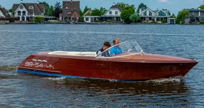 houten motorboot op water met twee personen