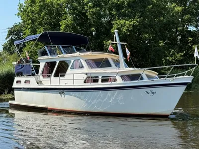 motorjacht op water met groene oever