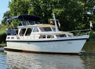 motorjacht op water met groene oever