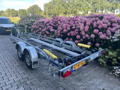 boottrailer op oprit met bloemen op achtergrond