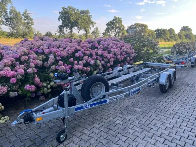 aanhanger op oprit bij hortensiastruiken