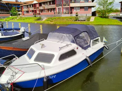 kleine kajuitboot afgemeerd bij steiger