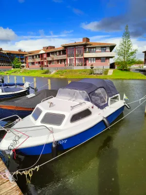 kleine kajuitboot afgemeerd bij steiger