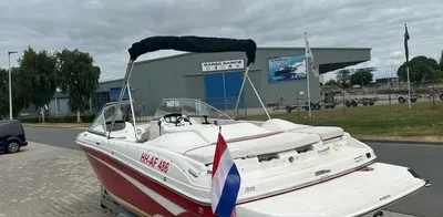rood-witte bowrider op trailer bij gebouw