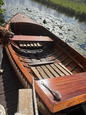 houten sloep op water met waterlelies